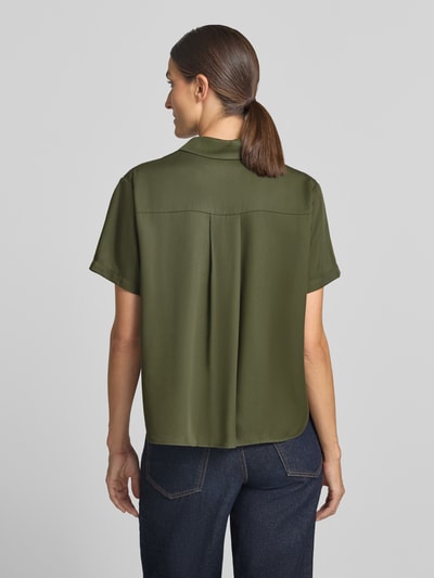 Frauenmodel trägt Relaxed Fit Bluse aus reinem Lyocell Modell 'Mina' von Samsøe Samsøe in Olivgrün, glatte Textur, Ganzkörperansicht Rückansicht. Damen Bluse, Hemdblusenkragen, kurzärmliges Design, Rückenlänge 60 cm, Ärmellänge 22 cm.