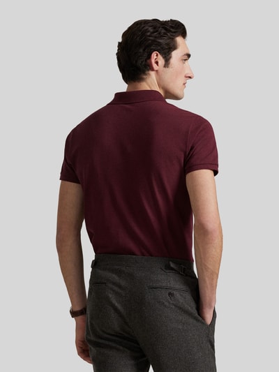 Männermodel trägt Slim Fit Poloshirt aus reiner Baumwolle von Polo Ralph Lauren in dunklem Bordeauxrot, Ganzkörperansicht Rückansicht.