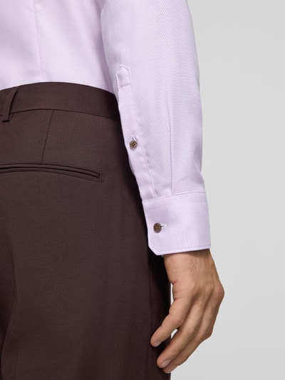 Männermodel trägt Slim Fit Businesshemd aus reiner Baumwolle von Seidensticker in Helllila, braune Hose, Nahaufnahme Oberkörper, Herren Businesshemd von Seidensticker.