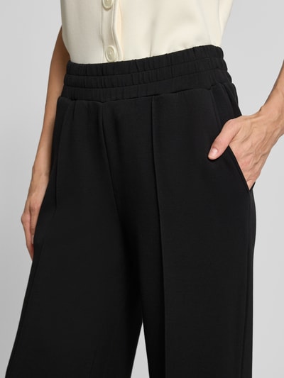 Vrouwenmodel draagt Wide Leg Sweatpants uit viscosemix van Varley, Dames sweatpants met stretch, Persplooien, elastische band, Binnenbeenlengte maat S 78 cm, Detailopname taille en heup