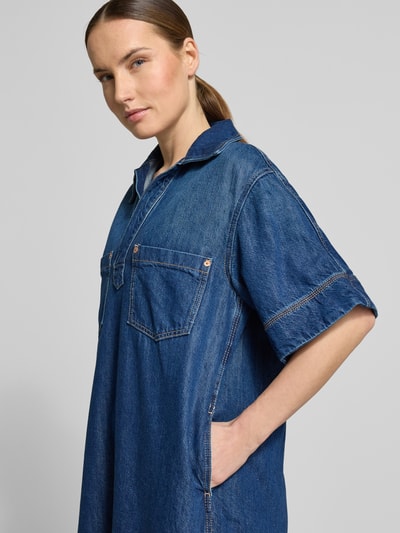 Frauenmodel trägt Regular-Fit Jeanskleid aus Baumwoll-Mix mit Lyocell-Anteil von BOSS Orange in Denim-Optik mit Twill-Material, Kurzarm, Brusttasche, Mini-Länge, Ganzkörperansicht von vorne.