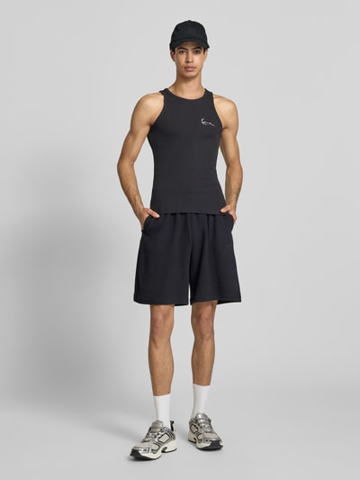 Männermodel trägt Regular Fit Shorts mit elastischem Bund von KARL KANI, Reine Baumwolle, Strukturmuster, Ganzkörperansicht von vorne.