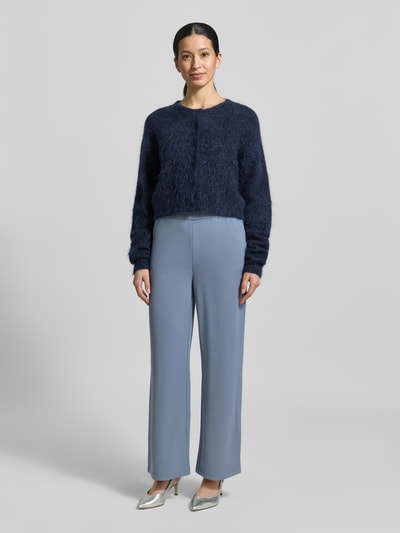 Modelka nosi Hose mit weitem Bein und Gesäßtaschen von Zero, jasnoniebieski materiał z elastycznym dodatkiem, szerokie nogawki, kieszenie z tyłu, Szerokość w rozmiarze 36: 35 cm, długość wewnętrzna nogawki: 71 cm, widok całej sylwetki z przodu.