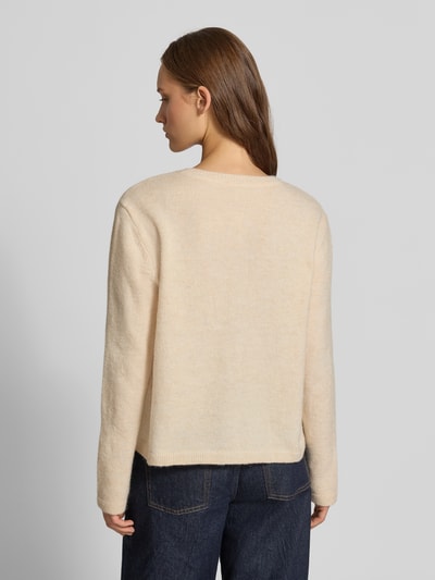 Frauenmodel trägt Regular Fit Strickjacke mit Rundhalsausschnitt Modell 'EVIA' von ONLY in Beige, kombiniert mit dunkler Jeans, Ganzkörperansicht Rückansicht, Damen Strickjacke von ONLY.