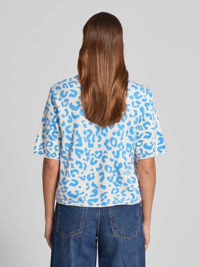 Frauenmodel trägt Relaxed Fit Shirt aus Viskose-Anteil Modell 'Mayas' von Vila, Strick-Optik, Allover-Animal-Print, Halbarm, Ganzkörperansicht Rückansicht.