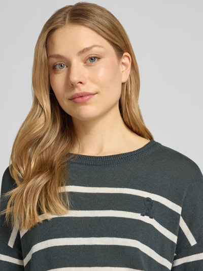 Frauenmodel trägt Relaxed Fit Pullover aus Leinen-Mix Modell 'STRIPE' von Armedangels, Streifen-Muster, Strick, Rundhals, Logo-Stitching, Nahaufnahme Oberkörper.