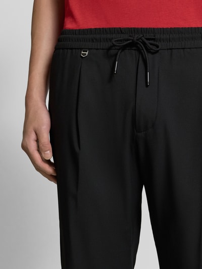 Mannenmodel draagt zwarte Stoffhose met elastische tailleband Modell 'NEIL' van Antony Morato, detailopname taille en heupen.