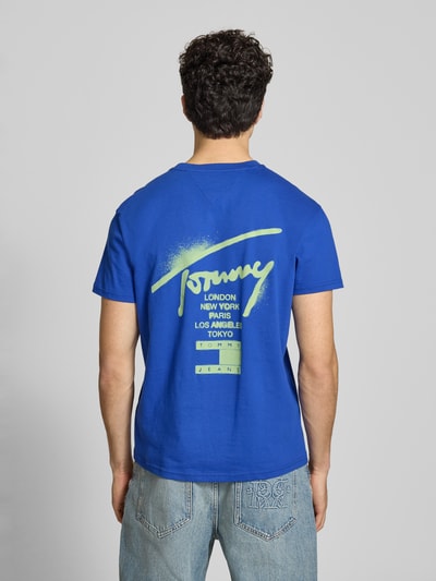 Männermodel trägt Regular Fit T-Shirt aus reiner Baumwolle von Tommy Jeans, Optik: Unifarben, Label-Schriftzug, Ganzkörperansicht Rückansicht.