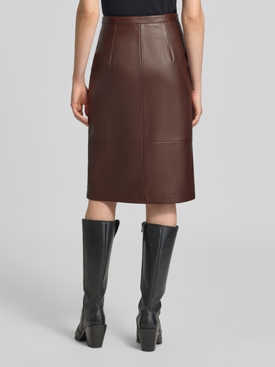 Frauenmodel trägt Schmaler Midi-Rock aus echtem Lammleder Modell 'Lacelo' von HUGO in Dunkelbraun, glatte Textur, Ganzkörperansicht Rückansicht, Damen Midi-Rock von HUGO