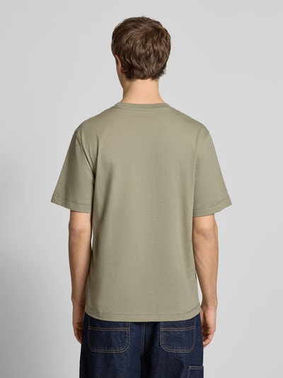 Männermodel trägt T-Shirt mit Label-Stitching Modell 'NORREBRO' von Jack & Jones in Olivgrün, Regular Fit, Ganzkörperansicht Rückansicht.
