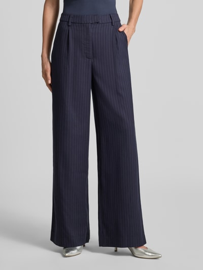 Frauenmodel trägt Straight Fit Anzughose mit Viskose-Anteil von LOLLYS LAUNDRY, dunkelblau mit feinen Streifen, Gürtelschlaufen, Nahaufnahme Oberkörper, elastischer Material-Mix, angedeutete Gesäßtaschen.