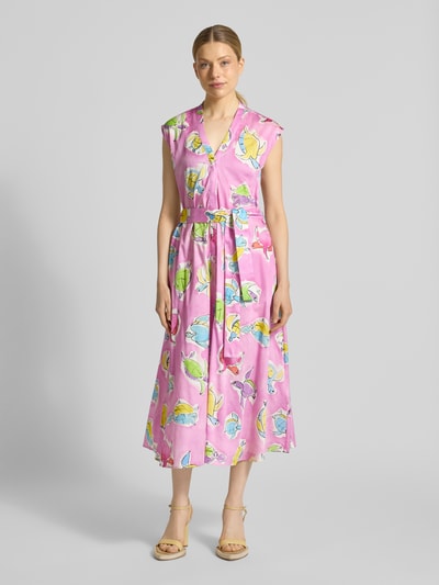 Modelka kobieca ma na sobie Midikleid mit V-Ausschnitt und Bindegürtel von Milano Italy, różowa bawełna, fason A-linii, kolorowe liście, szerokość w rozmiarze 36: 50 cm, długość tyłu 127 cm, całkowite ujęcie z przodu.