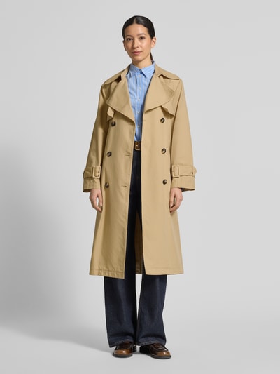 Vrouwenmodel draagt Regular Fit trenchcoat uit katoen-lyocell-mix van s.Oliver RED LABEL, effen kleuren, twill, mix van katoen en lyocell, dubbele knoopsluiting, platte kraag, tailleriem, loopsplit, schouderpatten, lange mouw met verstelbare boord, zijzakken, geheellichaamsaanzicht van voren.