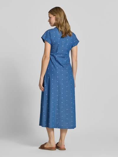 Kobiece modelka nosi Tailliertes Jeanskleid aus reiner Baumwolle Modell 'NOVA AZURE' von Only, denimowy niebieski kolor, wzór allover, długość midi, krótki rękaw, dekolt V, czysta bawełna, widok całej sylwetki z tyłu.
