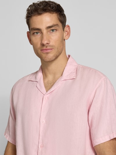Männermodel trägt Regular Fit Leinenhemd mit Reverskragen von MCNEAL in Hellrosa, reine Leinenstruktur, Knopfleiste, Nahaufnahme Oberkörper.