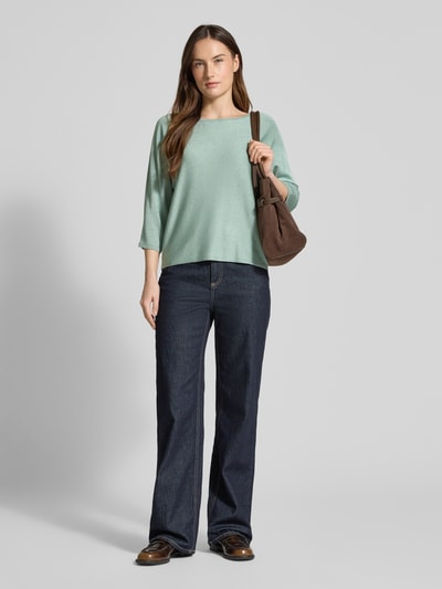 Frauenmodel trägt Relaxed Fit Pullover aus Viskose-Mix in Strick-Optik von comma, mintgrün, U-Boot-Ausschnitt, 7/8-Arm, Ganzkörperansicht von vorne.