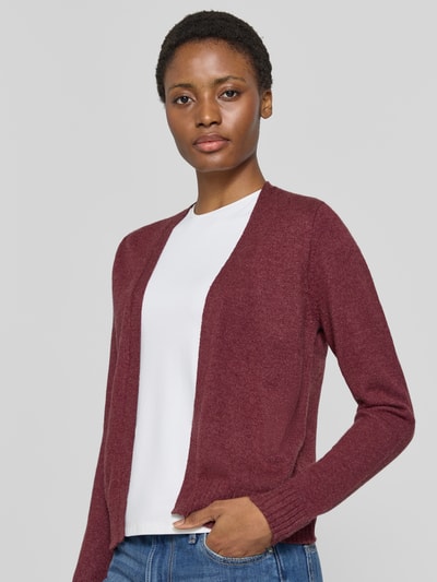 Frauenmodel trägt Strickjacke aus Viskose-Mix von VILA in Burgunderrot mit geripptem Bund und gerippten Ärmelabschlüssen, Nahaufnahme Oberkörper.