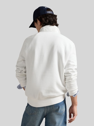 Männermodel trägt Relaxed Fit Troyer aus Baumwoll-Mix von Polo Ralph Lauren in Unifarbe Weiß, Struktur Sweat, Rippbündchen, Ganzkörperansicht Rückansicht.
