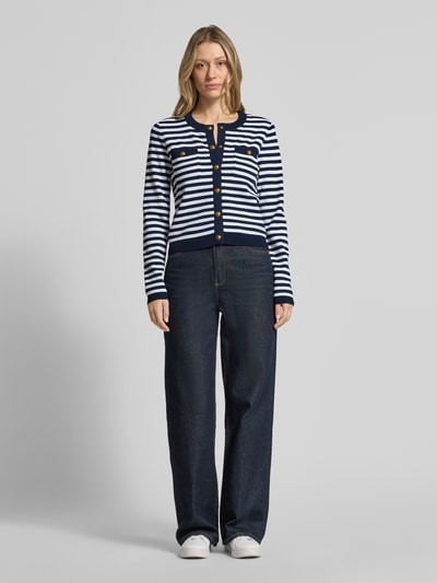 Frauenmodel trägt Strickjacke mit Rundhalsausschnitt und Knopfleiste von MICHAEL Michael Kors, Viskose-Mix mit Stretch-Anteil, Regular-Fit, marineblau-weiß gestreift, Rückenlänge 49 cm, Ärmellänge 64 cm, Ganzkörperansicht von vorne.