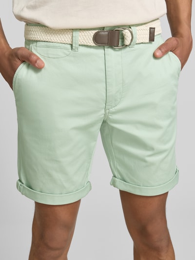Männermodel trägt Bermudas mit Gürtel und Eingrifftaschen von MCNEAL in Mintgrün, Straight Fit, Nahaufnahme Oberkörper. Baumwoll-Mix mit Stretch, sichtbare seitliche Eingrifftaschen, Gürtel und Saum mit Aufschlag.