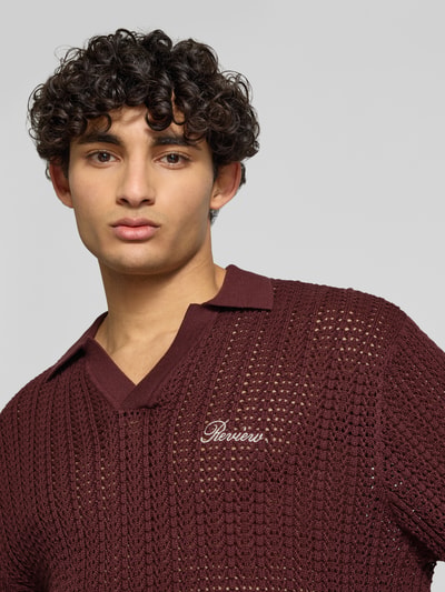 Męski model nosi Slim Fit Poloshirt in Crochet-Optik od REVIEW, bawełna, krój slim fit, półrękaw, logo, zbliżenie na górę ciała