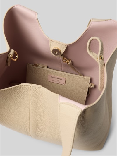 Produktfoto, Handtasche mit Tragehenkel von Coccinelle aus beigem, genarbtem Leder mit rosa Futter, Hauptfach mit Magnetverschluss, Label-Detail, Breite 34 cm, Länge 29 cm, Tiefe 14 cm, Schulterriemen 50 cm