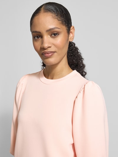 Vrouwenmodel draagt Regular Fit Sweatshirt uit modal-mix model 'TENNY' van Selected Femme, effen lichtroze, scuba-textuur, 3/4-balloonmouwen, crew neck, detailopname bovenlichaam.
