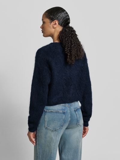 Frauenmodel trägt Cropped Strickjacke mit Knopfleiste Modell 'debbie' von Gestuz im Woll-Mohair-Mix mit Stretch-Anteil, Rückansicht.