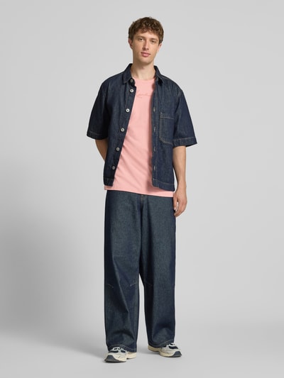 Männermodel trägt Regular Fit T-Shirt mit Logo-Stitching von KARL KANI in Rosa, Reine Baumwolle, Rundhalsausschnitt, Ganzkörperansicht von vorne, Rückenlänge bei Größe M: 73 cm.