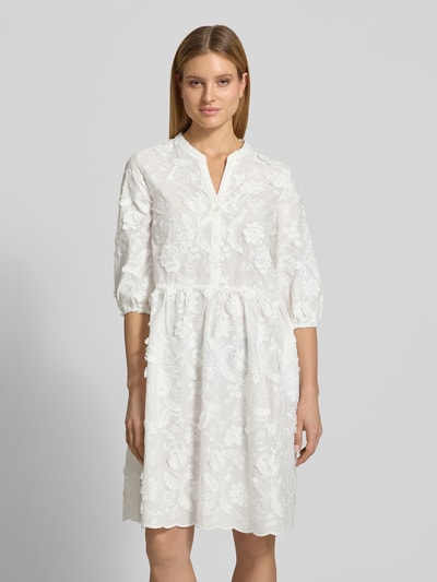 Frauenmodel trägt Knielanges Kleid mit Stitchings und 3/4-Arm von WHITE LABEL aus Reine Baumwolle, A-Linie, Tunikakragen, Knielänge, weißen floralen Mustern, feine Textur, Brustweite 48 cm bei Größe 36, Ärmel- und Rückenlänge angegeben, Ganzkörperansicht von vorne.