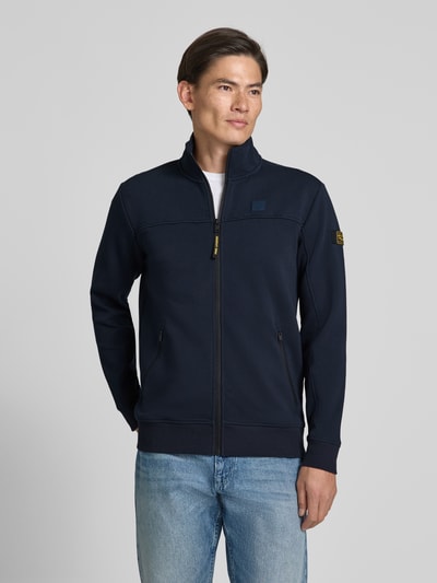 Männermodel trägt Sweatjacke mit Stehkragen und Label-Patch von PME Legend in Dunkelblau, Strukturmuster, Reißverschlusstaschen, Ganzkörperansicht von vorne.