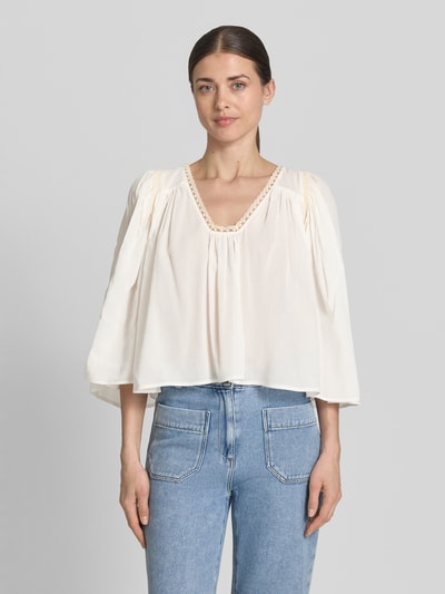 Frauenmodel trägt Cropped Bluse mit 3/4-Arm Modell 'ISMARA' von Drykorn, Cremefarbe, Baumwoll-Viskose-Mix, V-Ausschnitt, Ganzkörperansicht von vorne.