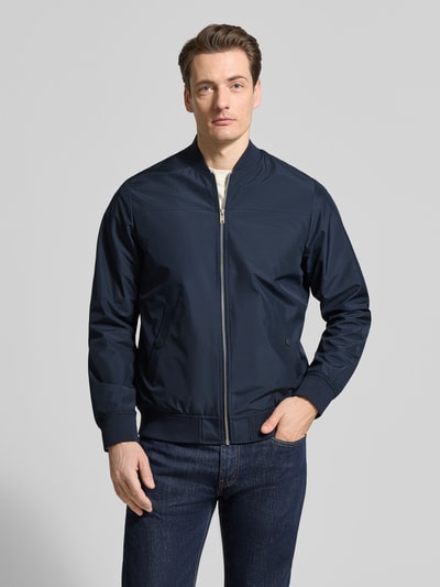 Männermodel trägt Jacke mit Stehkragen Modell 'clay' von Matinique in Dunkelblau, Regular-Fit, Reißverschluss, Eingrifftaschen, Ganzkörperansicht von vorne. Rückenlänge 67 cm, Schulterbreite 45 cm, Brustweite 56 cm, Ärmellänge 66 cm, Größe M.