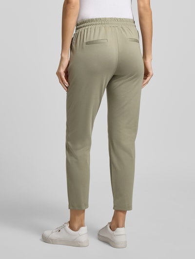 Frauenmodel trägt Slim Fit Stoffhose mit Viskose-Anteil Modell 'Rizet' von B.Young in Helloliv, elastischer Bund, 7/8-Länge, Ganzkörperansicht Rückansicht.
