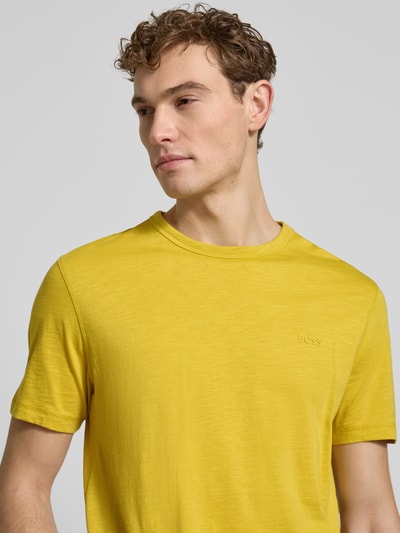 Männermodel trägt Regular Fit T-Shirt aus reiner Baumwolle Modell 'TEGOOD' von BOSS Orange in Unifarbe, Rundhals, Label Patch, Nahaufnahme Oberkörper