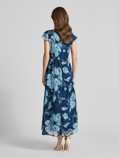 Frauenmodel trägt Maxikleid mit Schlüsselloch-Ausschnitt und Bindegürtel von More & More, Dunkelblau mit floralem Muster, Taillierter Schnitt, Rückenreißverschluss, Rückenlänge 135 cm, Brustweite 48 cm, Ärmellänge 4 cm, Ganzkörperansicht Rückansicht.