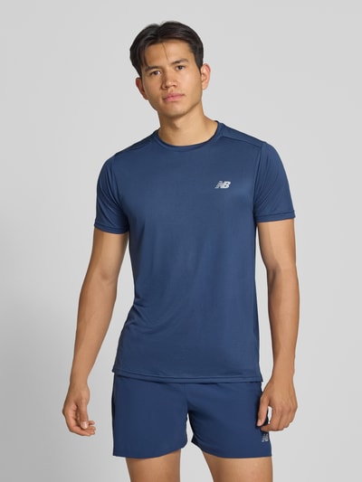 Männermodel trägt Funktionsshirt mit Rundhalsausschnitt und Logo von New Balance in Dunkelblau, glatte Oberfläche, Ganzkörperansicht von vorne, Rückenlänge bei Größe M 69 cm, Regular Fit