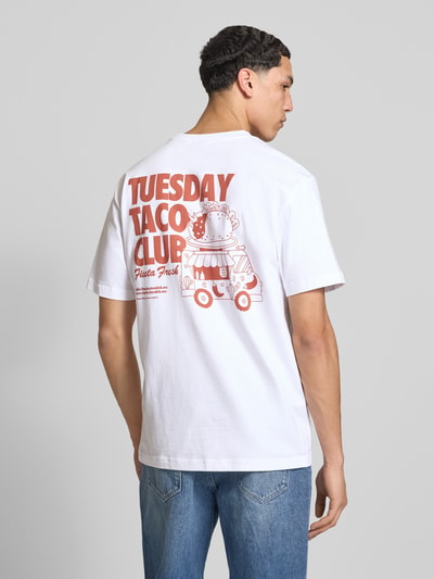 Männermodel trägt Relaxed Fit T-Shirt aus reiner Bio-Baumwolle Modell 'FRED' von Only & Sons, weiß mit Rücken-Print, Ganzkörperansicht Rückansicht.