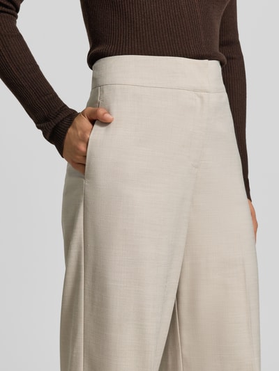 Frauenmodel trägt Wide Fit Hose mit Viskose-Anteil von MYON, hellbeige Farbe, elastischer Material-Mix, Nahaufnahme Oberkörper.