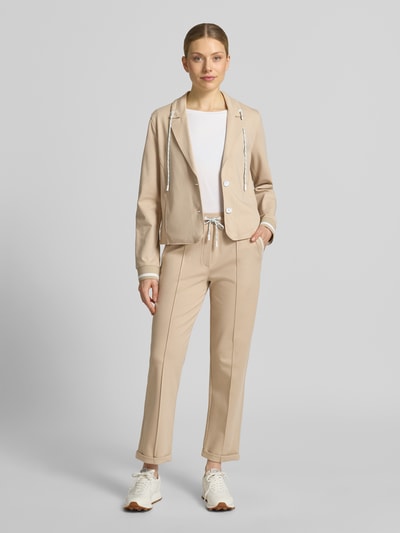 Vrouwenmodel draagt Straight Fit stoffen broek met siernaden van Marc Cain in beige, mix van katoen en modal, 7/8-lengte, bandwijdte maat 36: 39 cm, binnenbeenlengte maat 36: 70 cm, elastische band met tunnelkoord, vaste pijpboorden, frontaal volledig beeld.