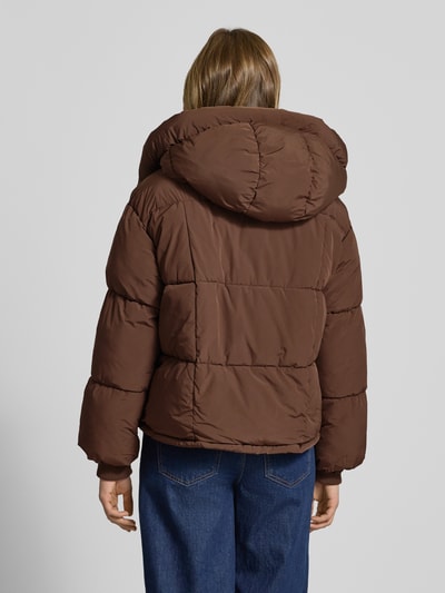 Frauenmodel trägt Regular Fit Steppjacke mit Kapuze Modell 'CORNELIA' von Only, unifarben braun, Ganzkörperansicht Rückansicht.