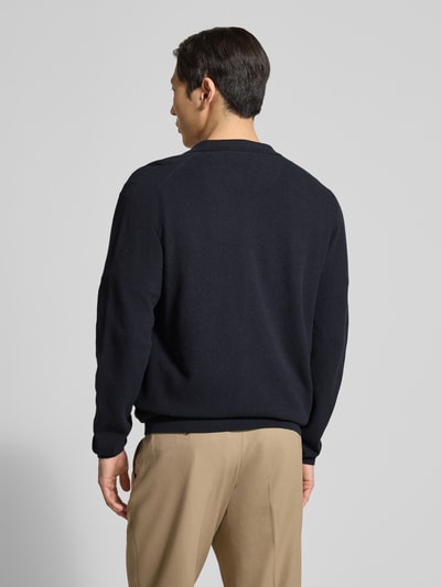 Männermodel trägt gebreid jack met borstzak en gestikt logo van Fynch-Hatton, puur katoen, recht model, platte kraag, knoopsluiting, ruglengte maat M 69 cm, mouwlengte maat M 65 cm, opgestikte steekzakken, heren, Ganzkörperansicht Rückansicht.