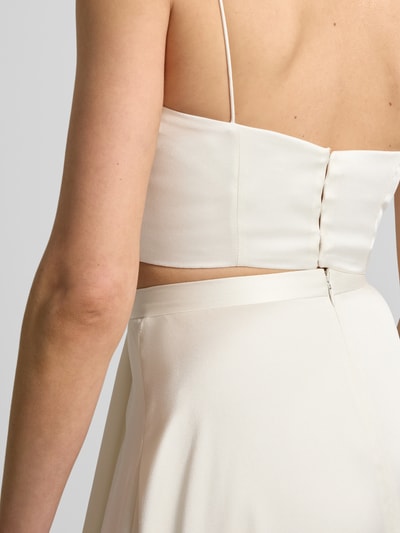 Frauenmodel trägt Relaxed Fit Abendkleid mit Gehschlitz von Jake*s Cocktail, cremefarbener Satin, Spaghettiträger, Detailaufnahme Rücken.