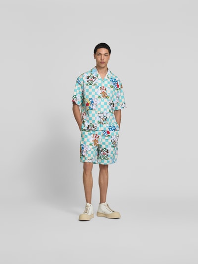 Männermodel trägt Freizeithemd mit Allover-Motiv-Print von Kenzo, Reine Baumwolle, Relaxed-Fit, Reverskragen, Kurzärmelig, bunte Muster, Ganzkörperansicht von vorne.