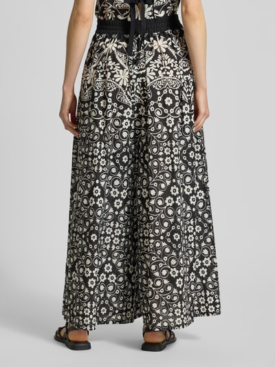 Vrouwenmodel draagt Regular Fit Hosenrock uit pure katoen model 'PALANCA' van Weekend Max Mara met allover-motief, high waist, elastische tailleband en zijzakken, zwart-wit kleuren, vloeiende stoftextuur, geheel achteraanzicht.
