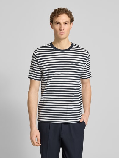 Männermodel trägt Regular Fit T-Shirt aus reiner Baumwolle von Marc O'Polo mit Allover-Streifenmuster, kurzarm, Jersey, Ganzkörperansicht von vorne.