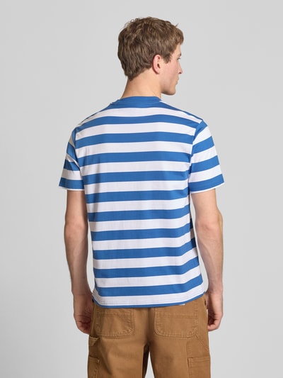 Männermodel trägt Herren T-Shirt mit blauen und weißen Streifen, Reine Baumwolle, Regular-Fit, T-Shirt mit Label-Stitching Modell 'RIVERGROVE' von Dickies, Rundhalsausschnitt, Rückenlänge bei Größe M: 71 cm, Ganzkörperansicht Rückansicht.