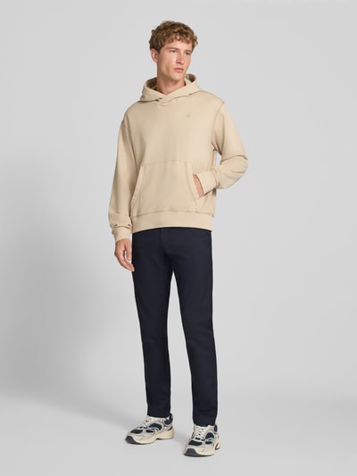 Männermodel trägt dunkelblaue Skinny Fit Hose aus Baumwoll-Mix Modell 'SID' von Carhartt Work In Progress, Ganzkörperansicht von vorne. Baumwoll-Mix mit Stretch-Anteil, Knopf- und Reißverschluss, seitliche Eingrifftaschen, Gesäßtaschen.