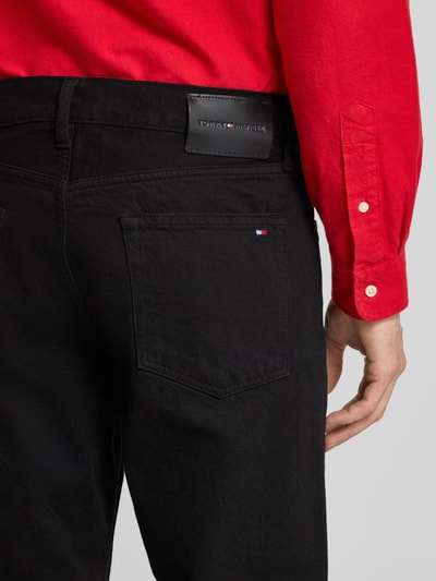 Männermodel trägt Straight Leg Jeans aus reiner Baumwolle von Tommy Hilfiger in Optik: Unifarben, 5-Pocket-Design, Detailaufnahme Rückansicht.