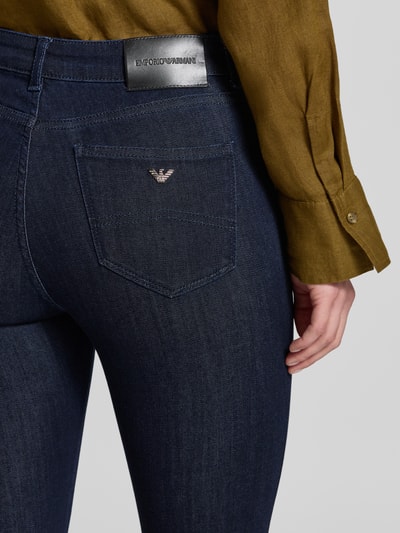 Frauenmodel trägt Slim Fit Jeans aus Viskose-Mix mit Lyocell-Anteil von Emporio Armani in Dunkelblau, 5-Pocket-Design, Nahaufnahme Rückansicht.